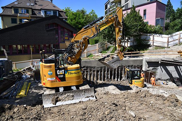 Der Bagger 315F arbeitet mit Baumaterial auf der Baustelle.