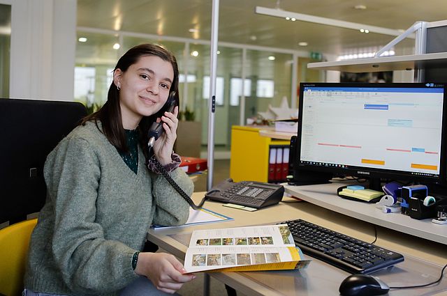 Unsere KV-Lernende telefoniert am Arbeitsplatz im Sekretariat