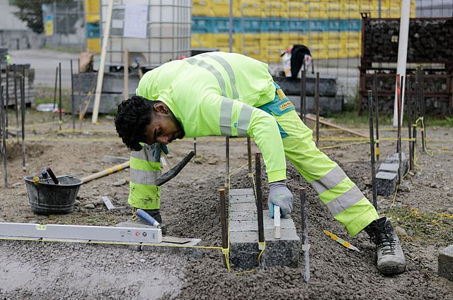 Unser Lernende Strassenbauer setzt Randabschlüsse auf einer Baustelle