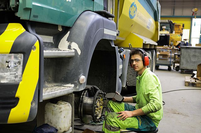 Lernender Automobilmechatroniker Nutzfahrzeuge ersetzt die Bremsbeläge eines LKW