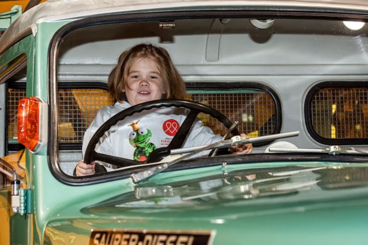 Ein Mädchen am Steuer eines Oldtimers